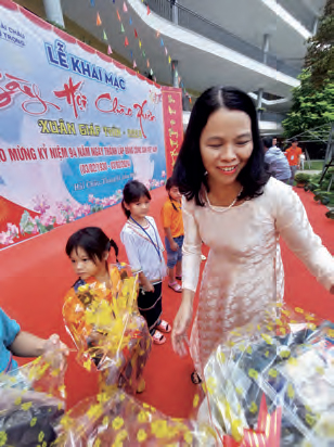 Cô giáo Trần Thị Lệ - Hiệu trưởng nhà trường ân cần trao quà cho các bạn học sinh miền núi.