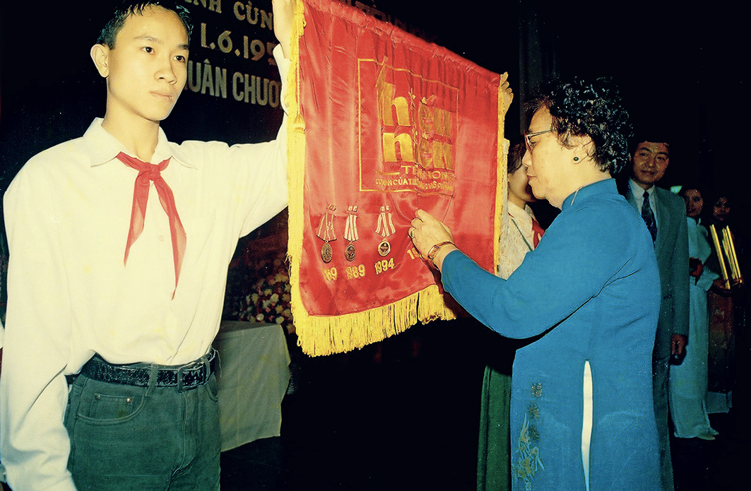 Phó Chủ tịch nước Nguyễn Thị Bình gắn Huân chương Độc lập hạng Nhất trong Lễ kỷ niệm 45 năm báo TNTP hành trình cùng tuổi thơ đất nước (31/5/1999).
