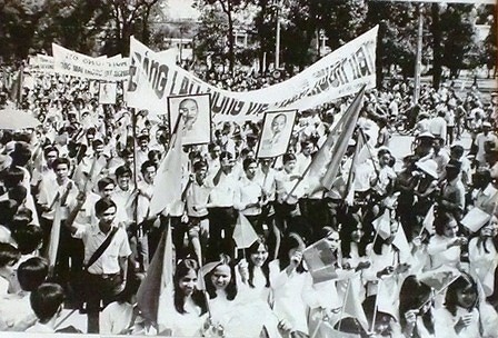Người dân Sài Gòn đổ ra đường vui mừng chiến thắng với hình ảnh Chủ tịch Hồ Chí Minh trong ngày thống nhất.