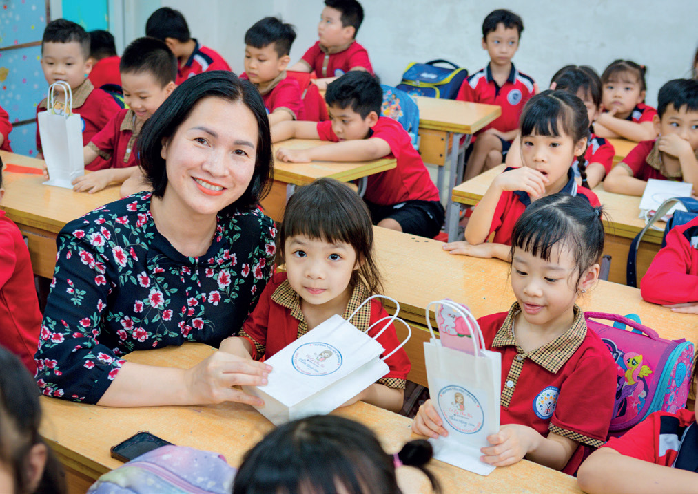Cô giáo Đào Thị Thúy - Hiệu trưởng trường TH Yên Hòa trao quà cho các bé mầm non tới thăm trường.