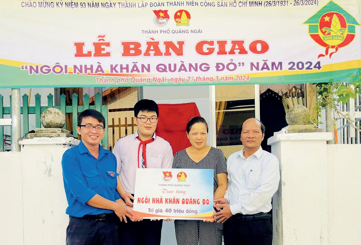 Anh Phạm Quang Châu (áo xanh) bàn giao “Ngôi nhà
Khăn quàng đỏ” cho gia đình bạn Trần Nguyễn Huy Hoàng.