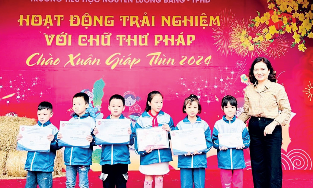 Cô giáo Nguyễn Thị Thư - Hiệu trưởng nhà trường, trao quà tặng của báo TNTP&NĐ cho các bạn học sinh tích cực tham gia phong trào “Viết, đọc và làm theo báo Đội”.