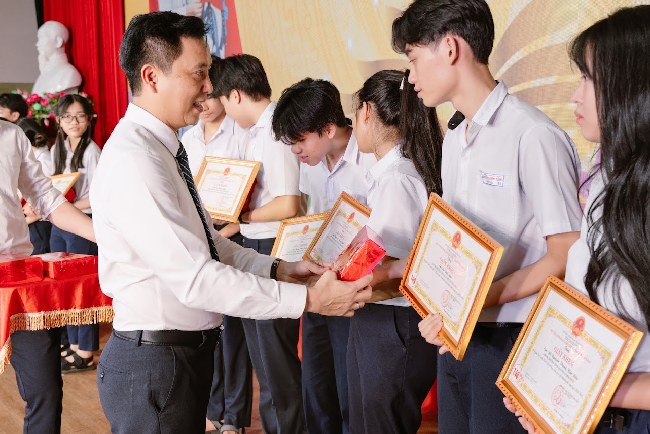 Nhà giáo Nguyễn Thanh Lịch trao Bằng khen cho các bạn học sinh.
