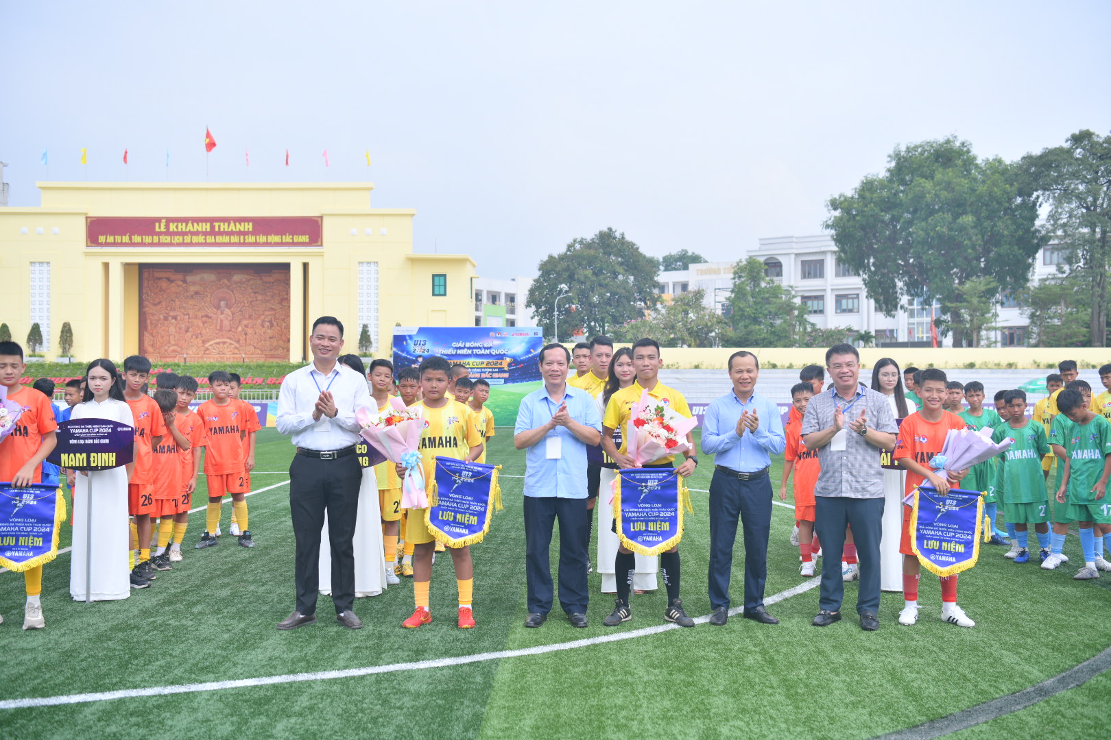 Các đại biểu tặng hoa và cờ lưu niệm cho 11 đội bóng tham dự vòng loại Khu vực I Bắc Giang.
