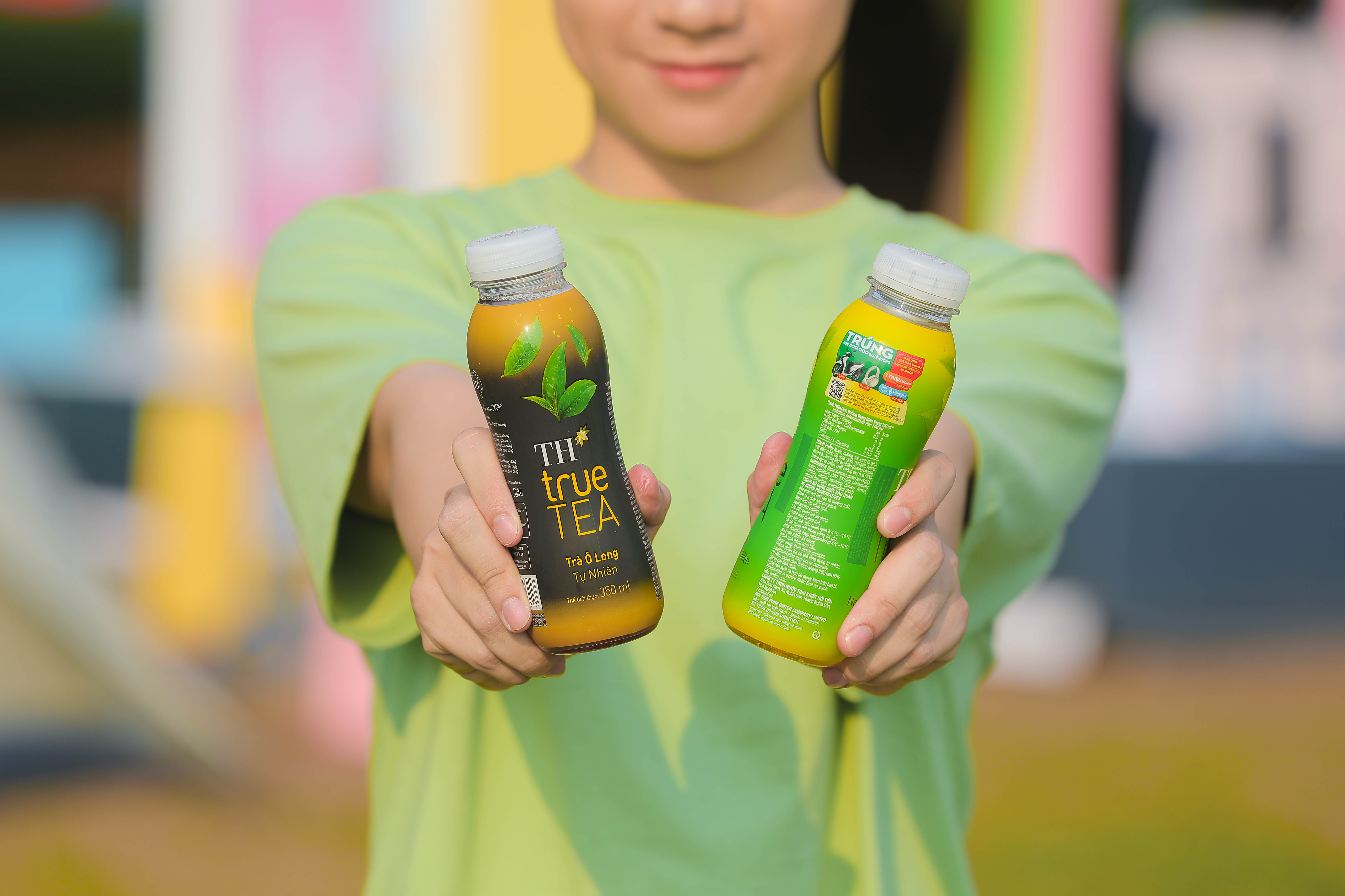 Nhãn chai Trà tự nhiên TH true TEA in thông tin chương trình khuyến mại.