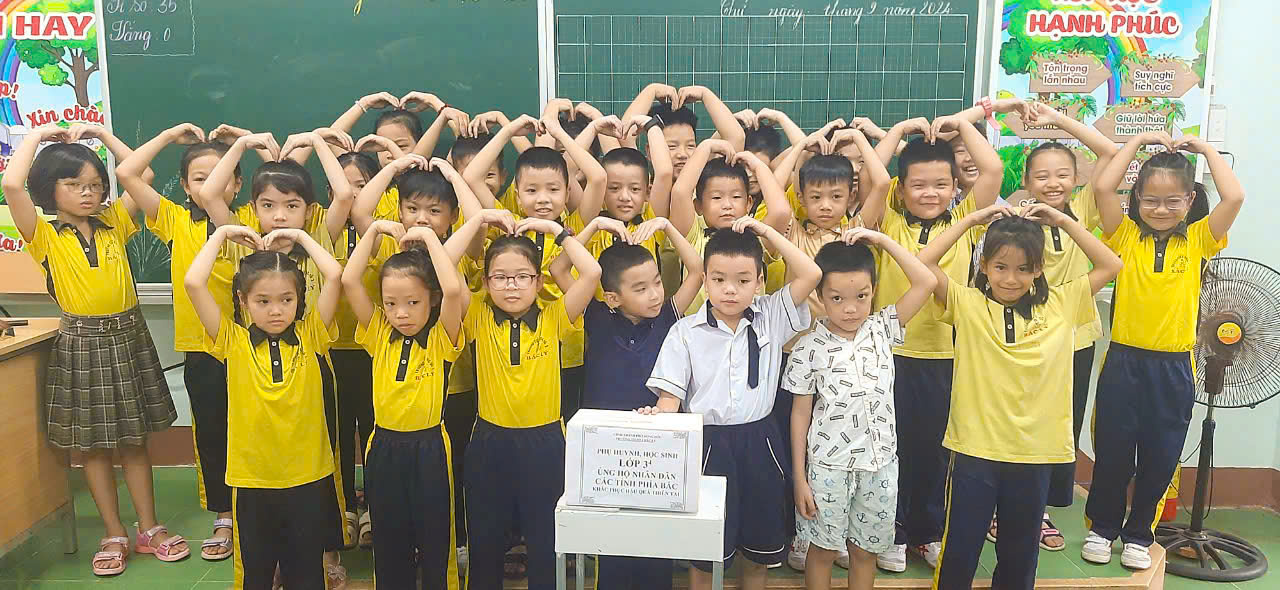 Cô và trò trường Tiểu học Bắc Lý số 2 ủng hộ đồng bào chịu ảnh hưởng của bão Yagi.