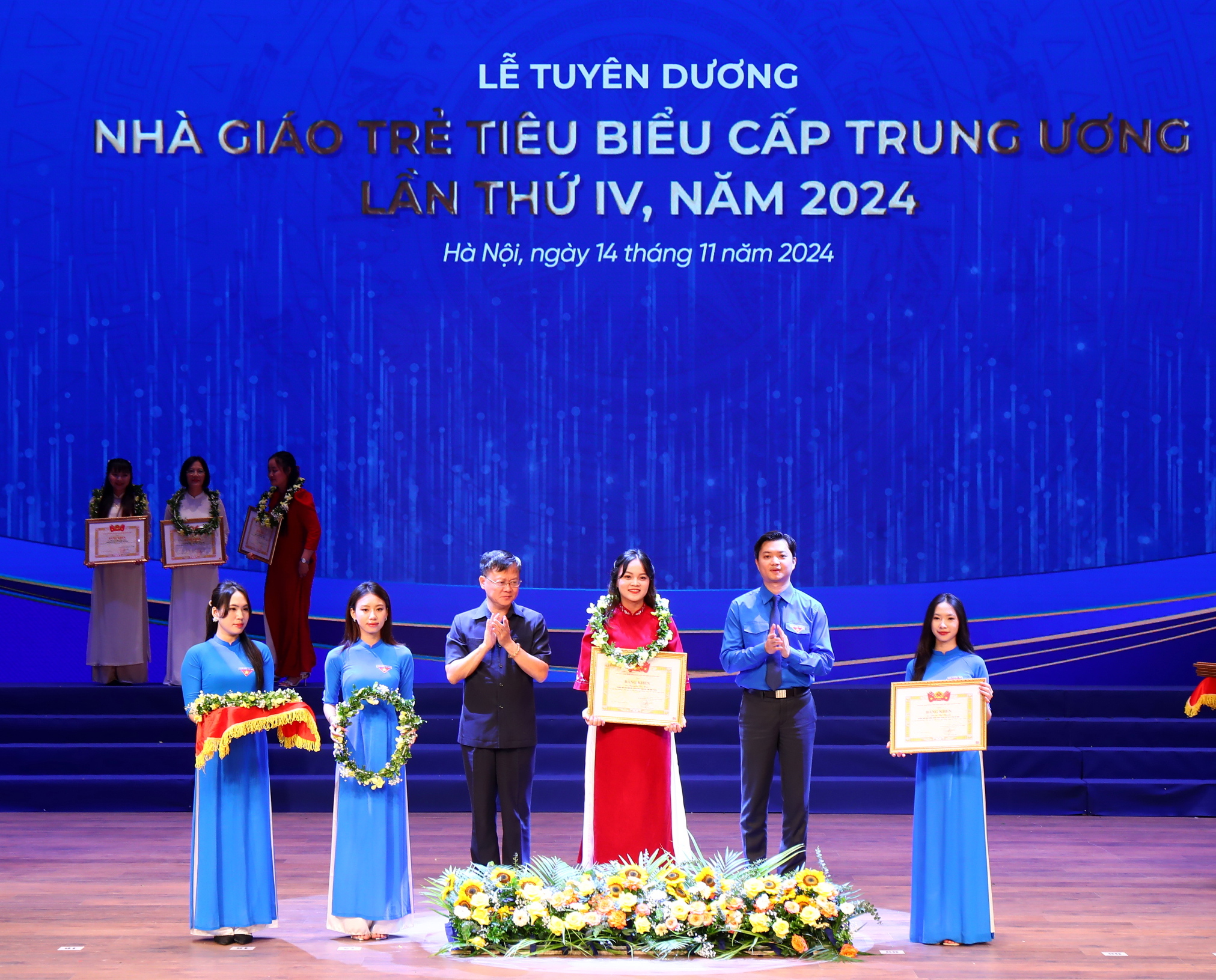 Đồng chí Nguyễn Minh Triết, Bí thư Trung ương Đoàn và đồng chí Vũ Huy Văn, Phó Vụ trưởng Vụ Tổng hợp, Văn phòng Trung ương Đảng trao Bằng khen và hoa cho Nhà giáo trẻ tiêu biểu tại buổi lễ