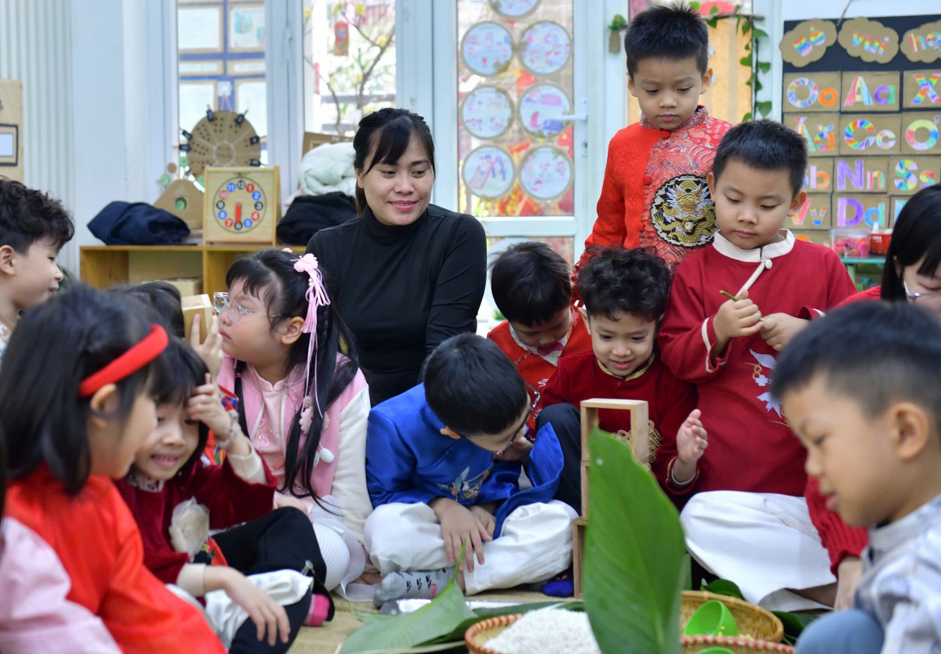 Cô Lại Bạch Liên (áo đen) hướng dẫn các bạn nhỏ làm bánh chưng.