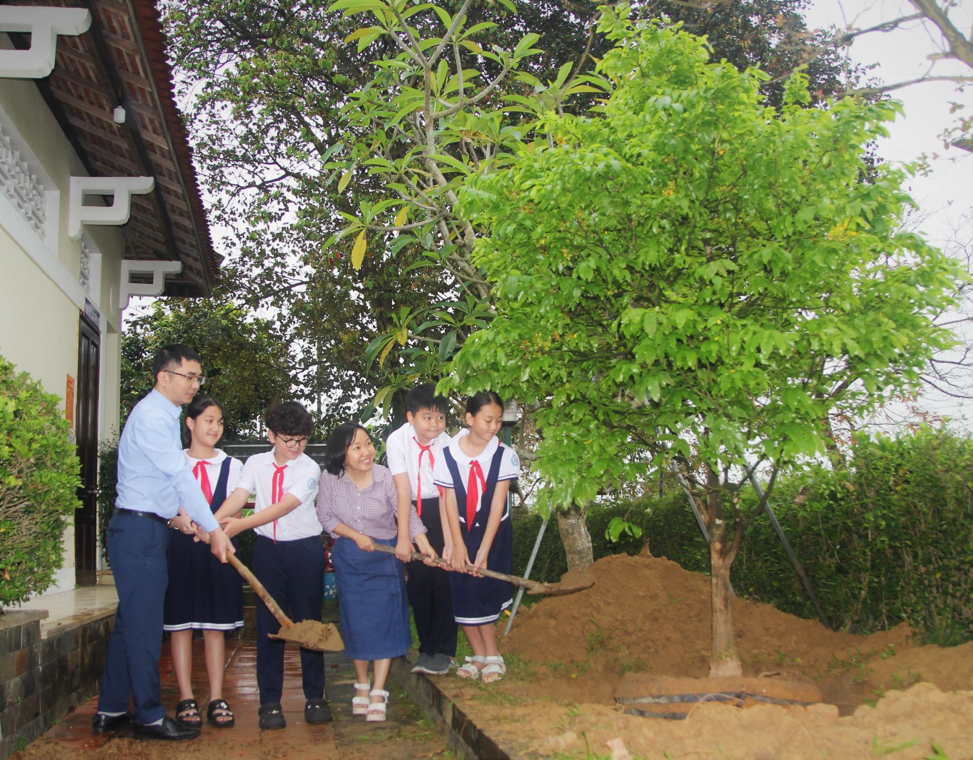 Đại diện báo TNTP&NĐ và Bảo tàng Hồ Chí Minh (TP. Huế) cùng các bạn học sinh vun đất trồng cây hoang mai tại di tích lịch sử tại làng Dương Nỗ