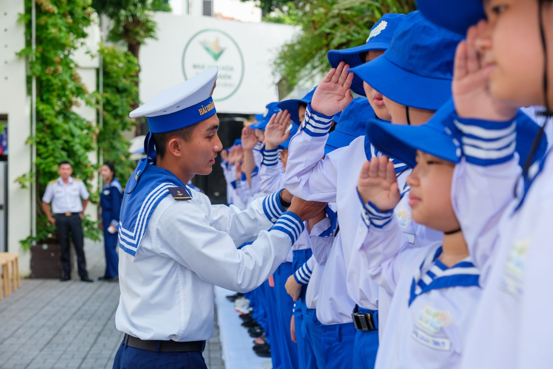 Chiến sĩ Hải quân hướng dẫn và chỉnh động tác chào theo điều lệnh cho các học viên.