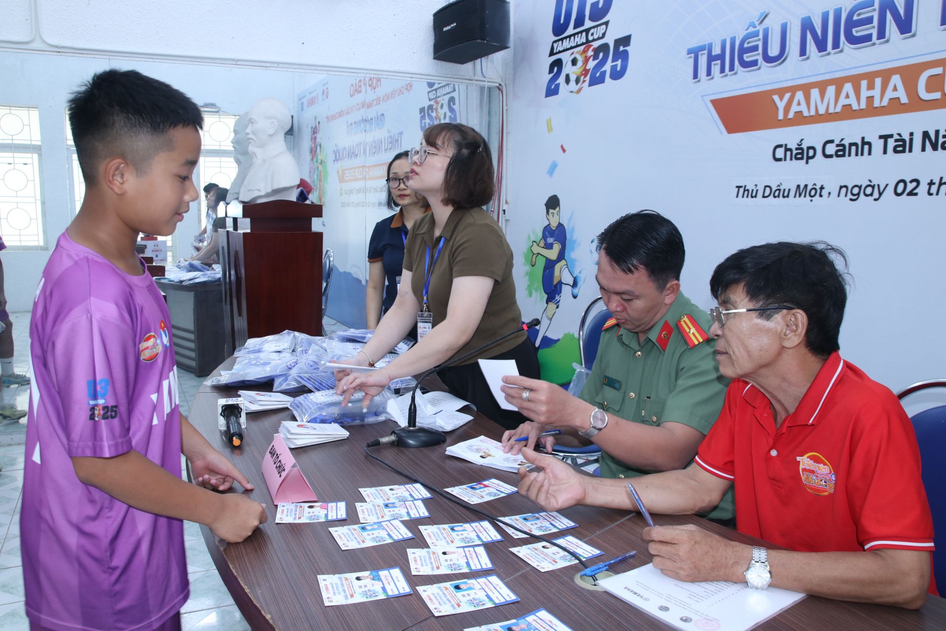 Các cầu thủ tiến hành việc đối chiếu thông tin cầu thủ theo sổ thi đấu với cán bộ công an