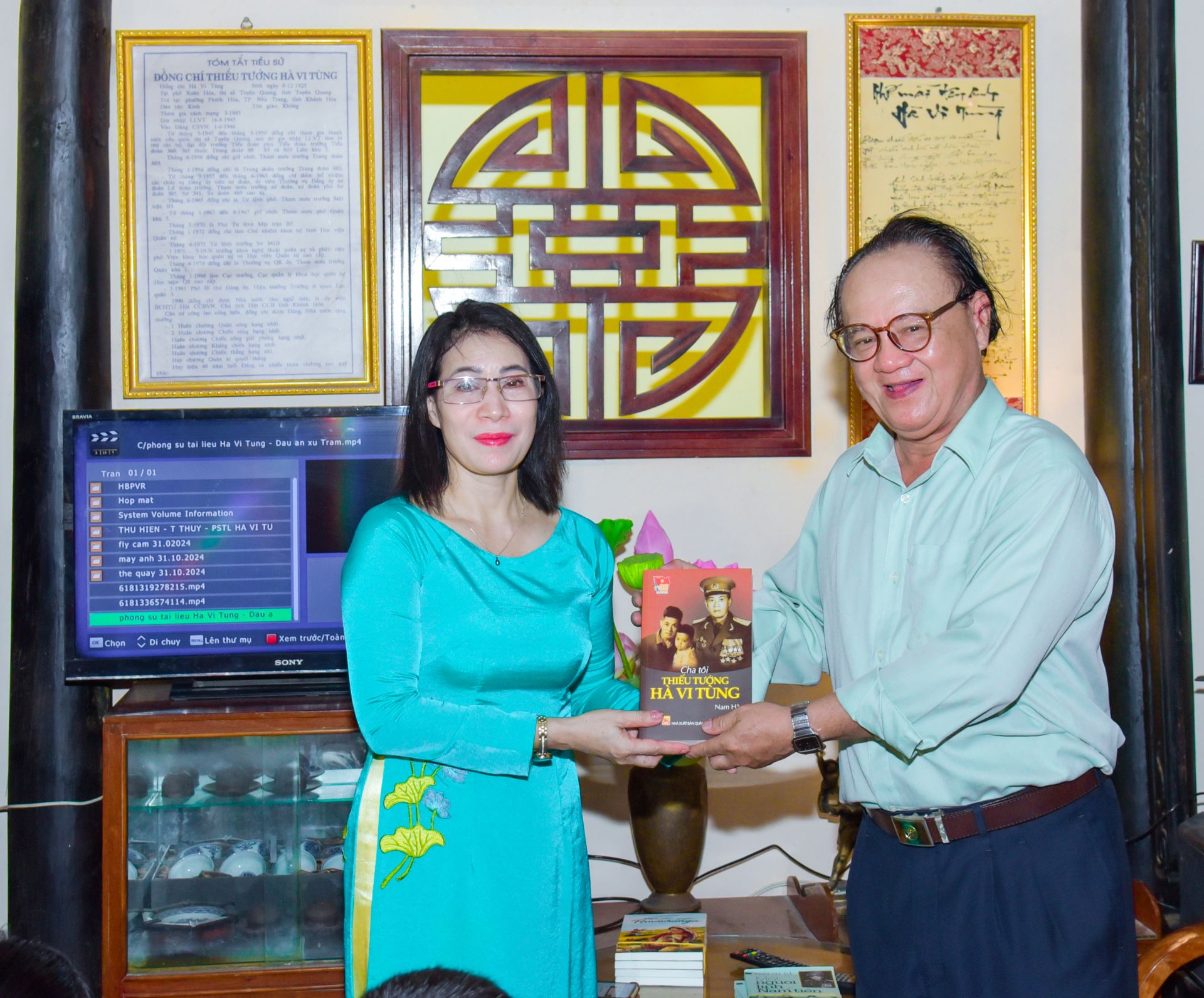 Nhà giáo Trần Thị Thu Hà - Hiệu trưởng trường TH Vĩnh Phương 2 xúc động đón nhận món quà của gia đình cố Thiếu tướng Hà Vi Tùng. Cuốn sách này sẽ để tại thư viện của nhà trường