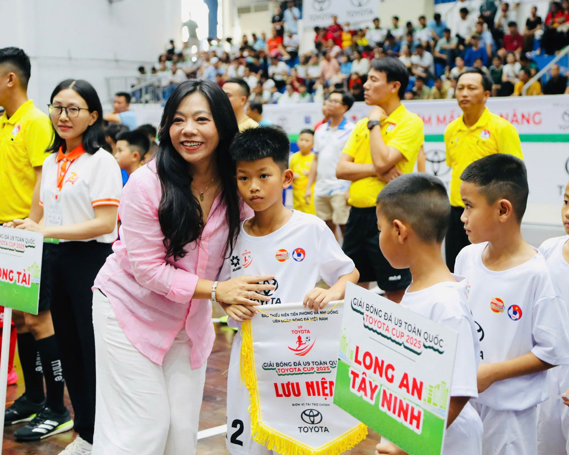 Bà Hoàng Thị Như Quỳnh - Trưởng ban Hành chính và Trách nhiệm xã hội, Công ty Ô tô Toyota Việt Nam, đại diện Nhà tài trợ chính của Giải trao cờ lưu niệm cho các cầu thủ U9 Bà Hoàng Thị Như Quỳnh - Trưởng ban Hành chính và Trách nhiệm xã hội, Công ty Ô tô Toyota Việt Nam, đại diện Nhà tài trợ chính của Giải trao cờ lưu niệm cho các cầu thủ U9