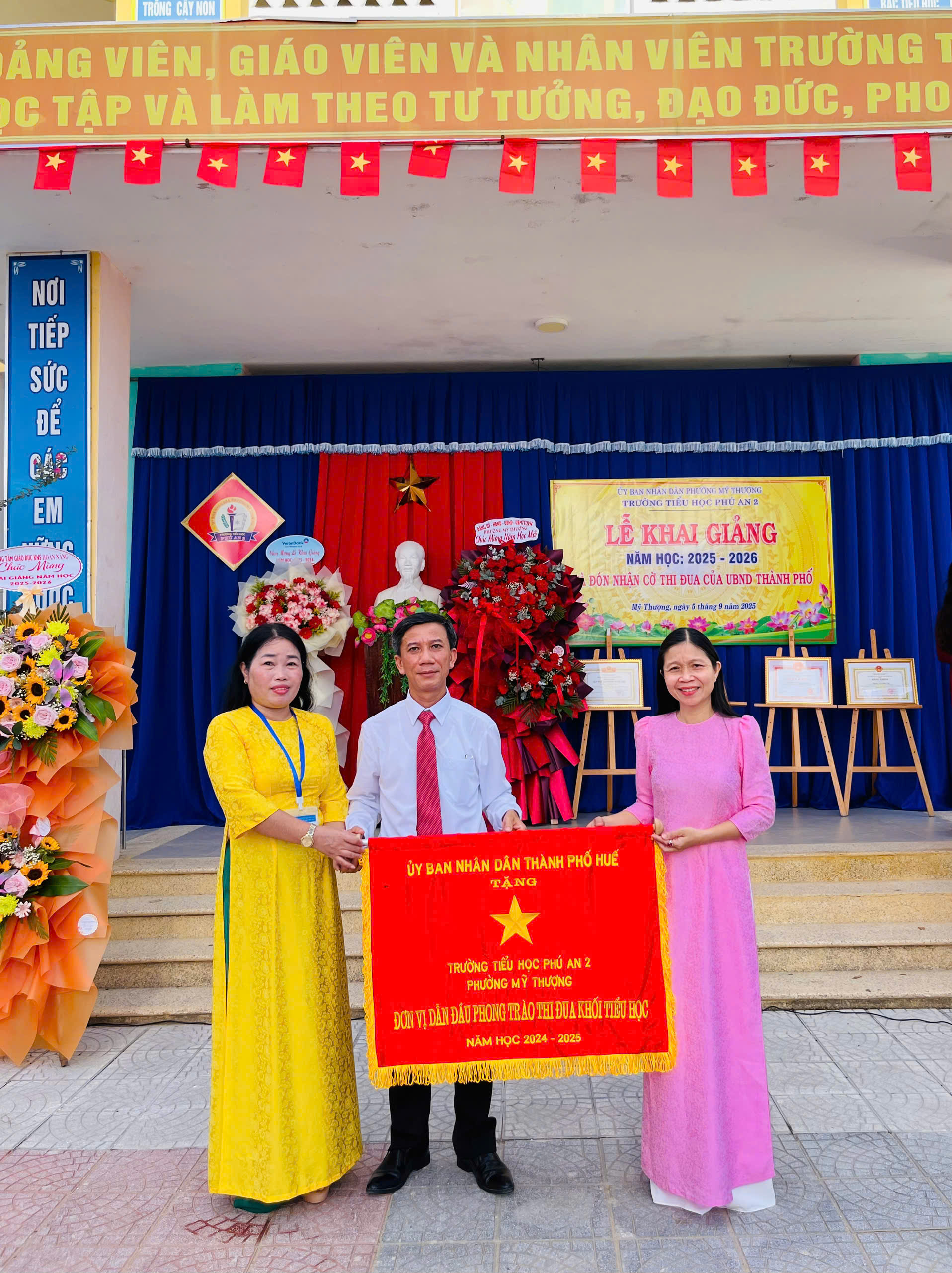 Phó Bí thư Thường trực Đảng ủy phường Mỹ Thượng - Nguyễn Thị Ánh Na (bên phải) trao cờ thi đua khối tiểu học của UBND thành phố Huế cho trường tiểu học Phú An 2 (phường Mỹ Thượng, thành phố Huế). Phó Bí thư Thường trực Đảng ủy phường Mỹ Thượng - Nguyễn Thị Ánh Na (bên phải) trao cờ thi đua khối tiểu học của UBND thành phố Huế cho trường tiểu học Phú An 2 (phường Mỹ Thượng, thành phố Huế).
