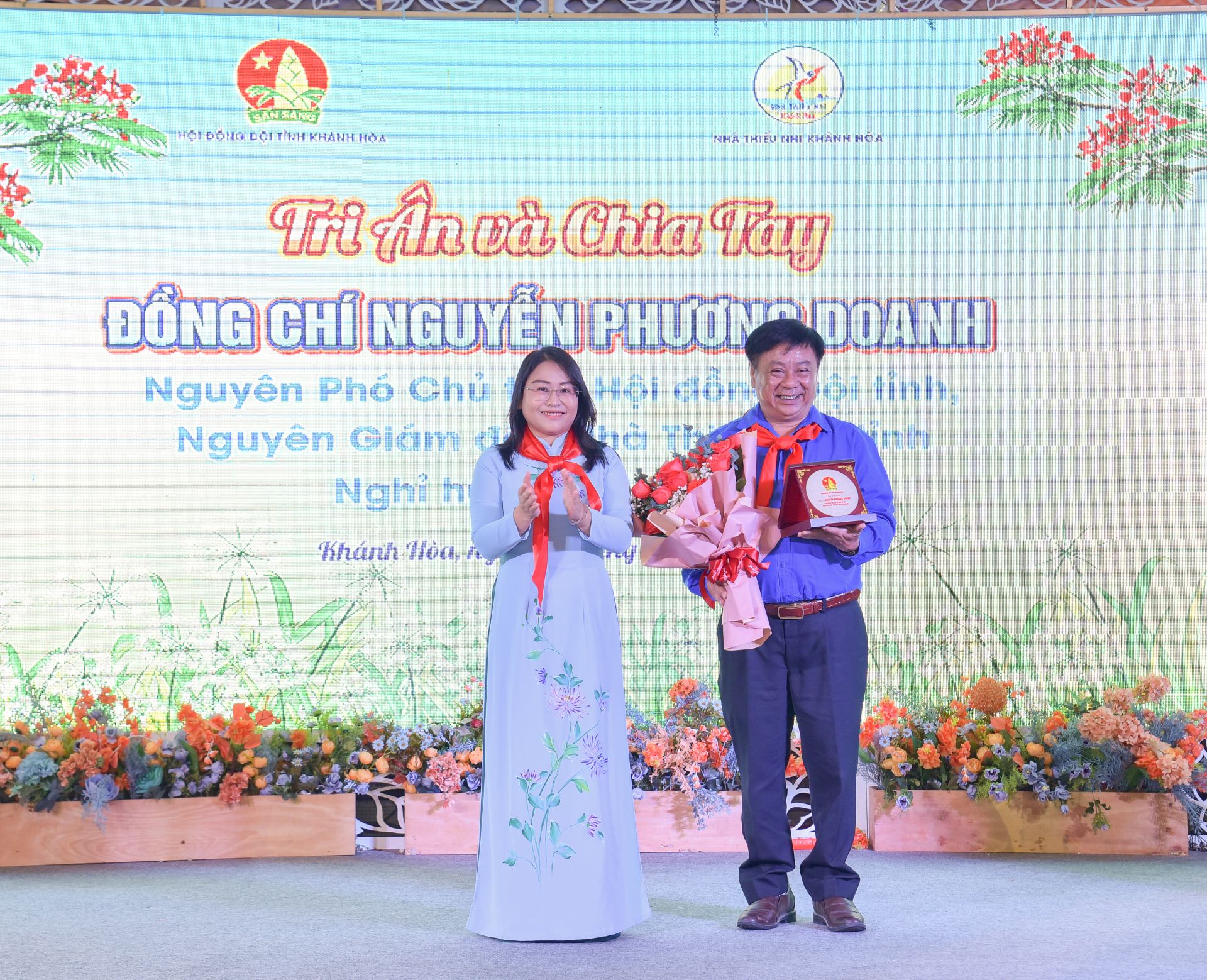 Chị Huỳnh Thị Như Ý - Phó Bí thư tỉnh đoàn, Chủ tịch Hội đồng Đội tỉnh, Giám đốc Nhà Thiếu nhi tỉnh tặng hoa, kỷ niệm chương tri ân, chia tay chú Nguyễn Phương Doanh - nguyên Giám đốc Nhà thiếu nhi.