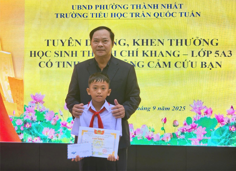 Thầy Trần Xuân Kỳ - Hiệu trưởng nhà trường khen thưởng cho em Thạch Chí Khang. 