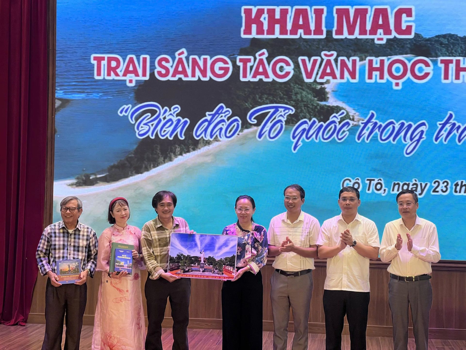 Bà Lê Ngọc Hân, Ủy viên BCH Đảng bộ tỉnh, Bí thư Đảng ủy, Chủ tịch HĐND Đặc khu Cô Tô cùng các lãnh đạo tặng bức ảnh Chủ tịch Hồ Chí Minh giữa biển trời Cô Tô cho trại sáng tác.