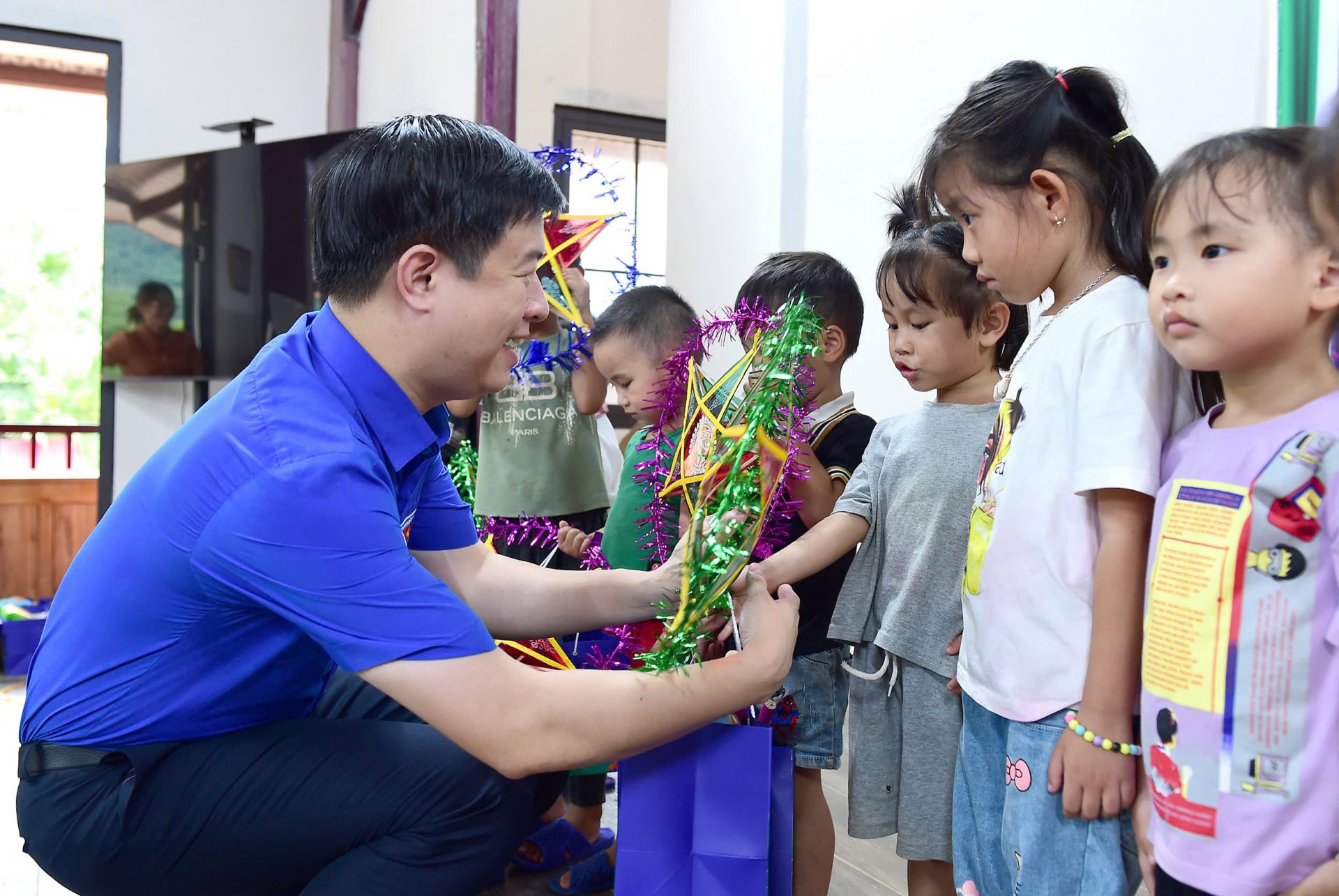 Chị Nguyễn Phạm Duy Trang và anh Lê Hải Long trao quà Trung Thu cho các em thiếu nhi Làng Nủ.