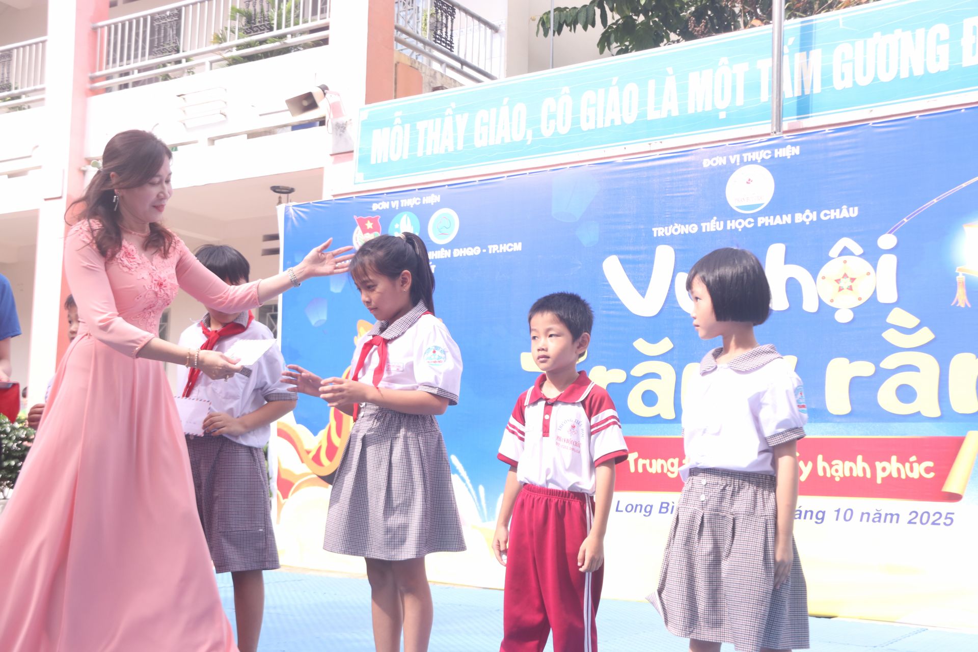 Cô Vũ Thị Thanh Bình (Hiệu trưởng trường tiểu học Phan Bội Châu, phường Long Bình, tỉnh Đồng Nai) trao quà trung thu đến các bạn.