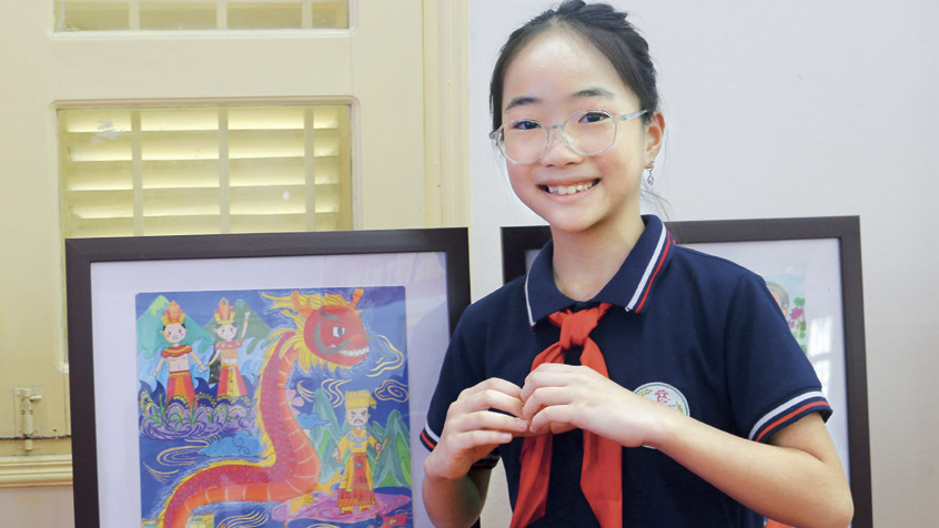 Phương Anh bên tác phẩm “Dòng máu Lạc Hồng” - bức tranh đoạt giải Nhất cuộc thi “Vui Hè em vẽ
- Tổ quốc em 80 năm rạng rỡ” cấp trường.