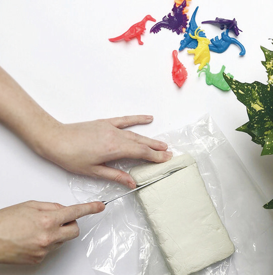 Bước 1: Dùng dao cắt một miếng đất sét nhỏ. Nếu đất khô quá, bạn cho thêm một chút xíu nước vào rồi bắt đầu nhào đều tay cho đến khi đất mềm ra.