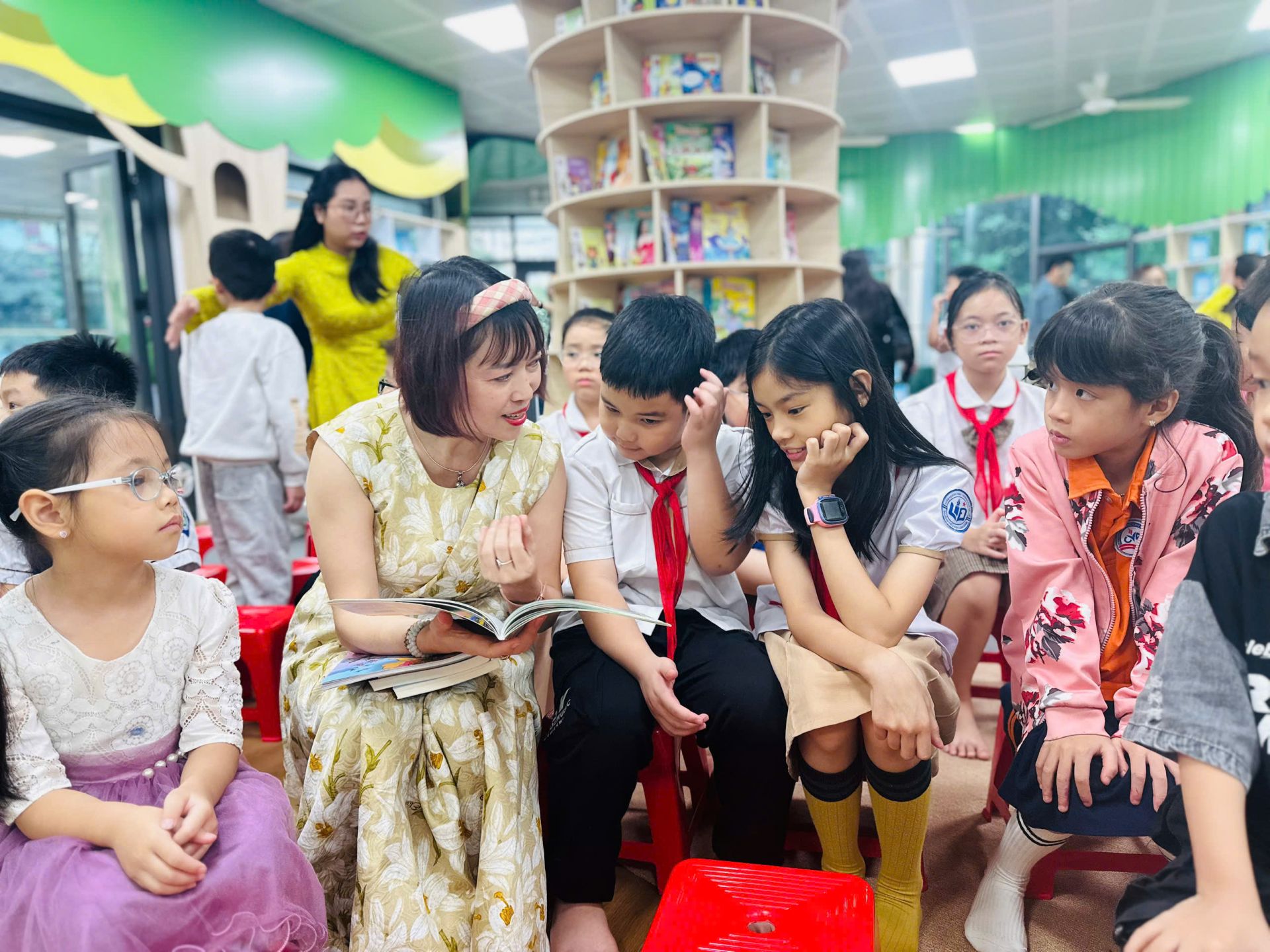 Các bạn học sinh trường Tiểu học Bùi Quốc Khái chăm chú nghe nhà thơ Bảo Ngọc giới thiệu về ấn phẩm Trạm dừng Yêu thương.