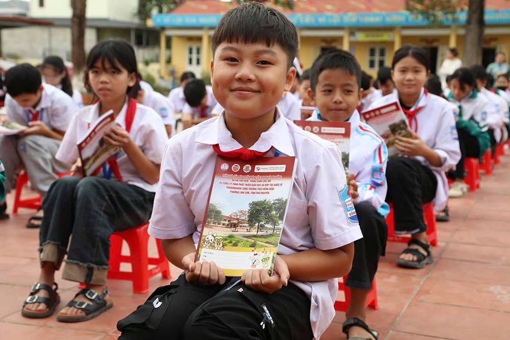 Niềm vui của các bạn học sinh khi được tặng những cuốn vở mới.