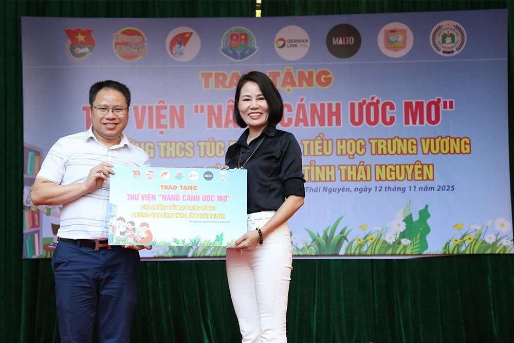 Đại diện Dự án trao bảng tượng trưng tặng Thư viện “Nâng cánh ước mơ” cho nhà trường.