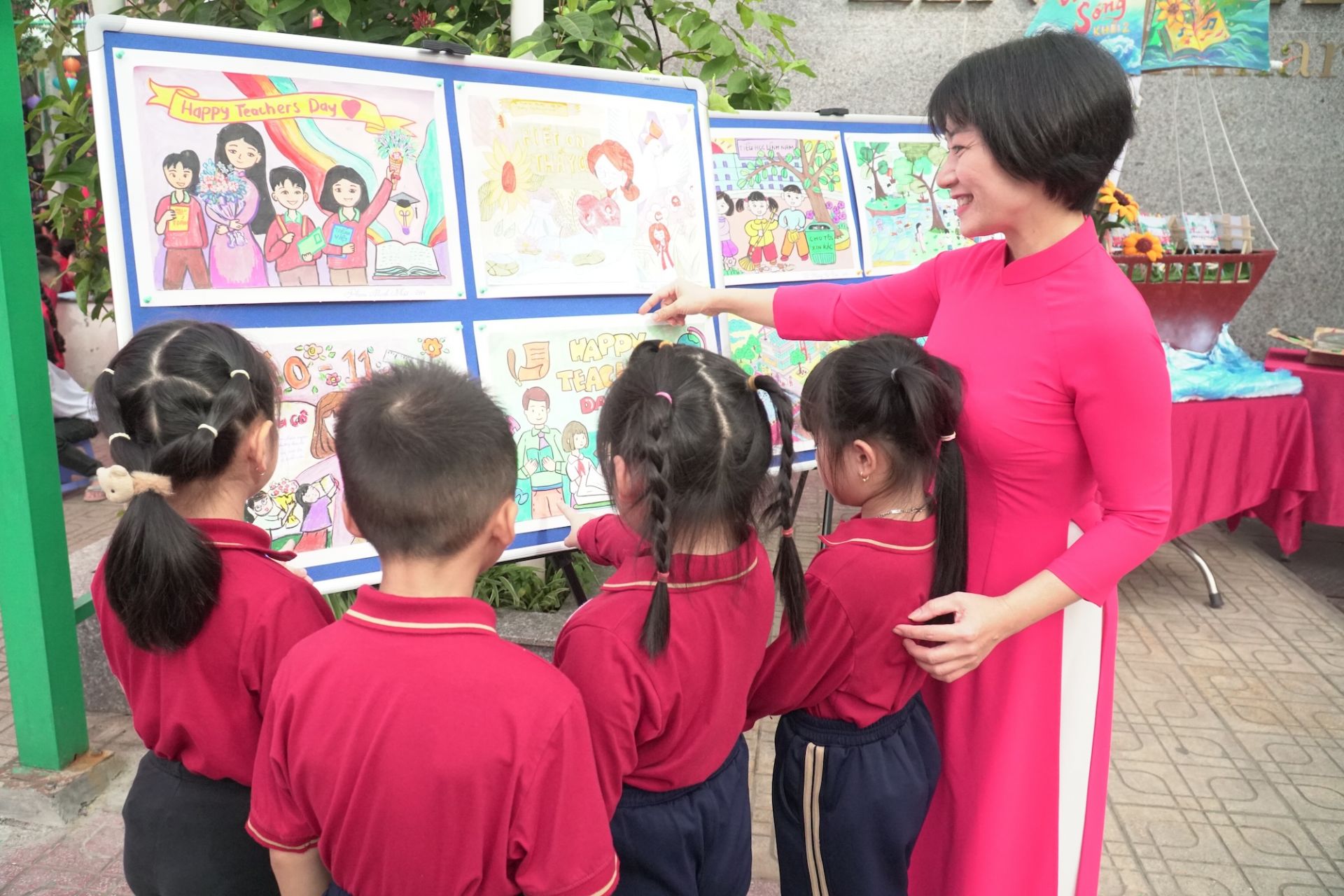 Cô và trò hào hứng tham quan không gian bích báo rực rỡ sắc màu.

