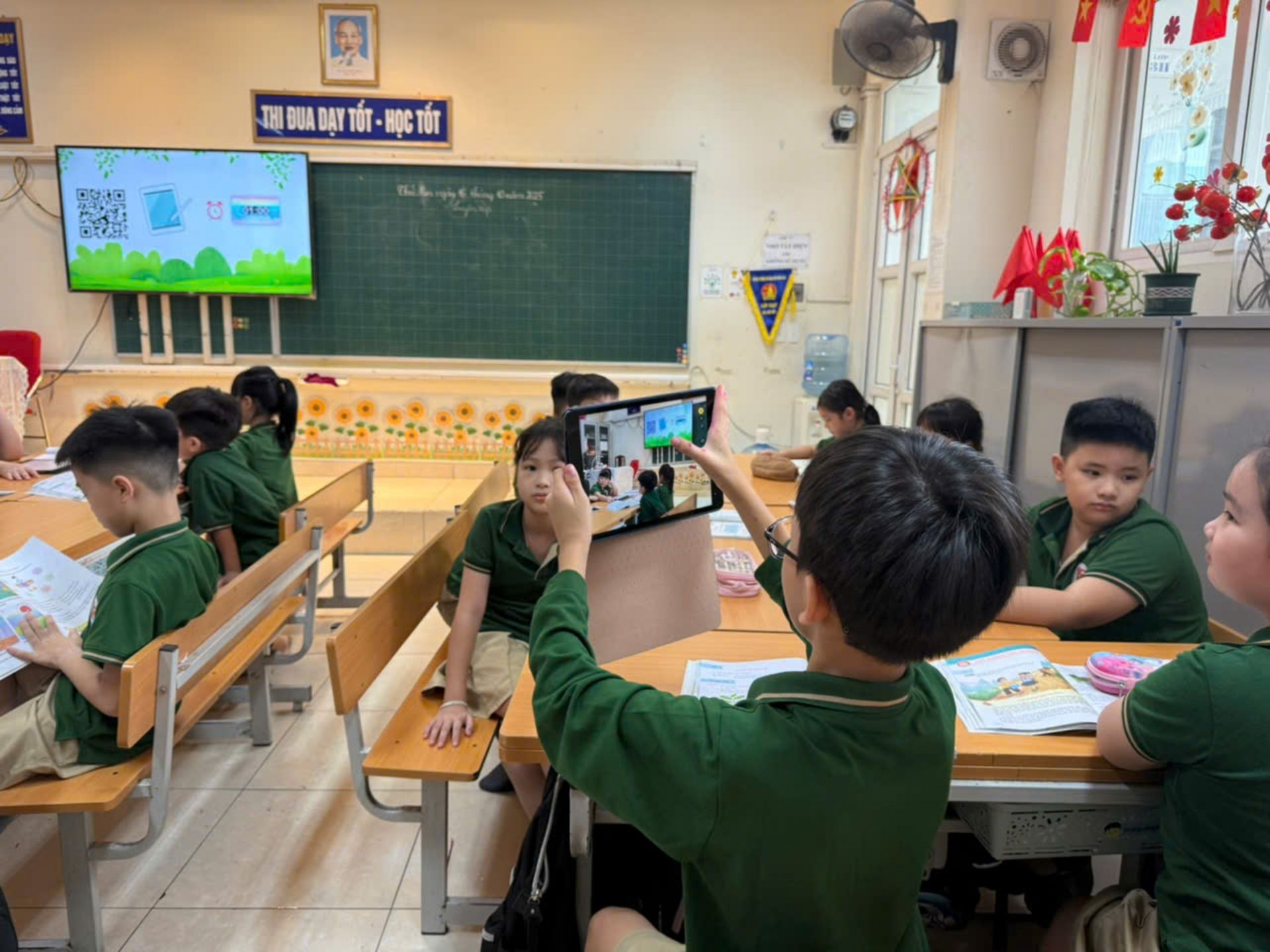 Học sinh dùng iPad quét mã QR trên màn hình để tham gia các nội dung bài học.