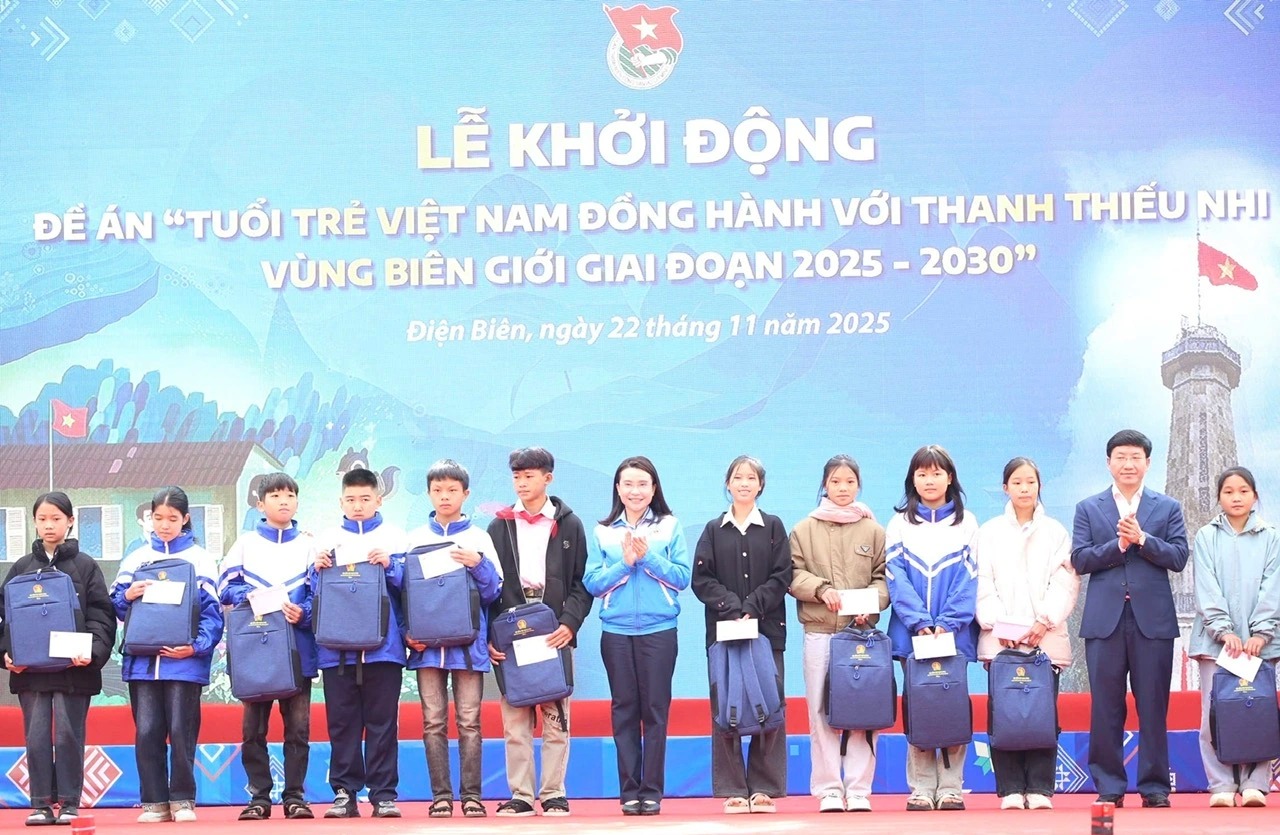 Chị Nguyễn Phạm Duy Trang và ông Mùa A Vảng trao tặng quà cho học sinh. 