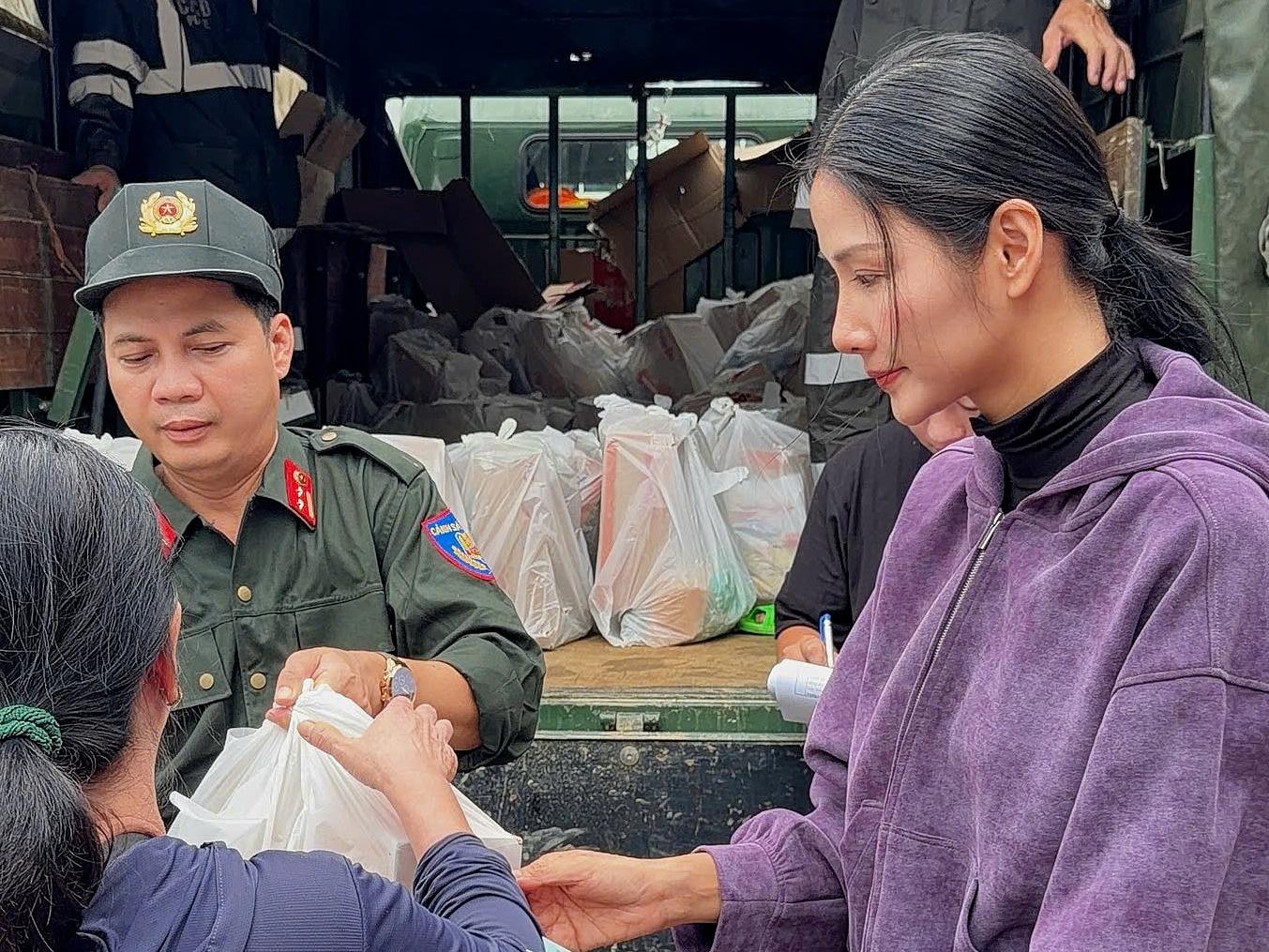 Hoàng Thùy trao tiền mặt hỗ trợ người dân.