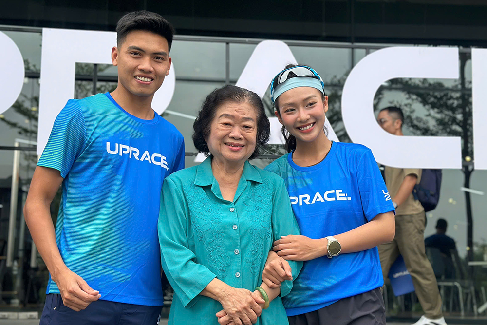 Hai đại sứ UpRace 2025 – diễn viên Khả Ngân và VĐV Trần Văn Đảng – chụp ảnh lưu niệm cùng đại diện Quỹ Vừ A Dính.