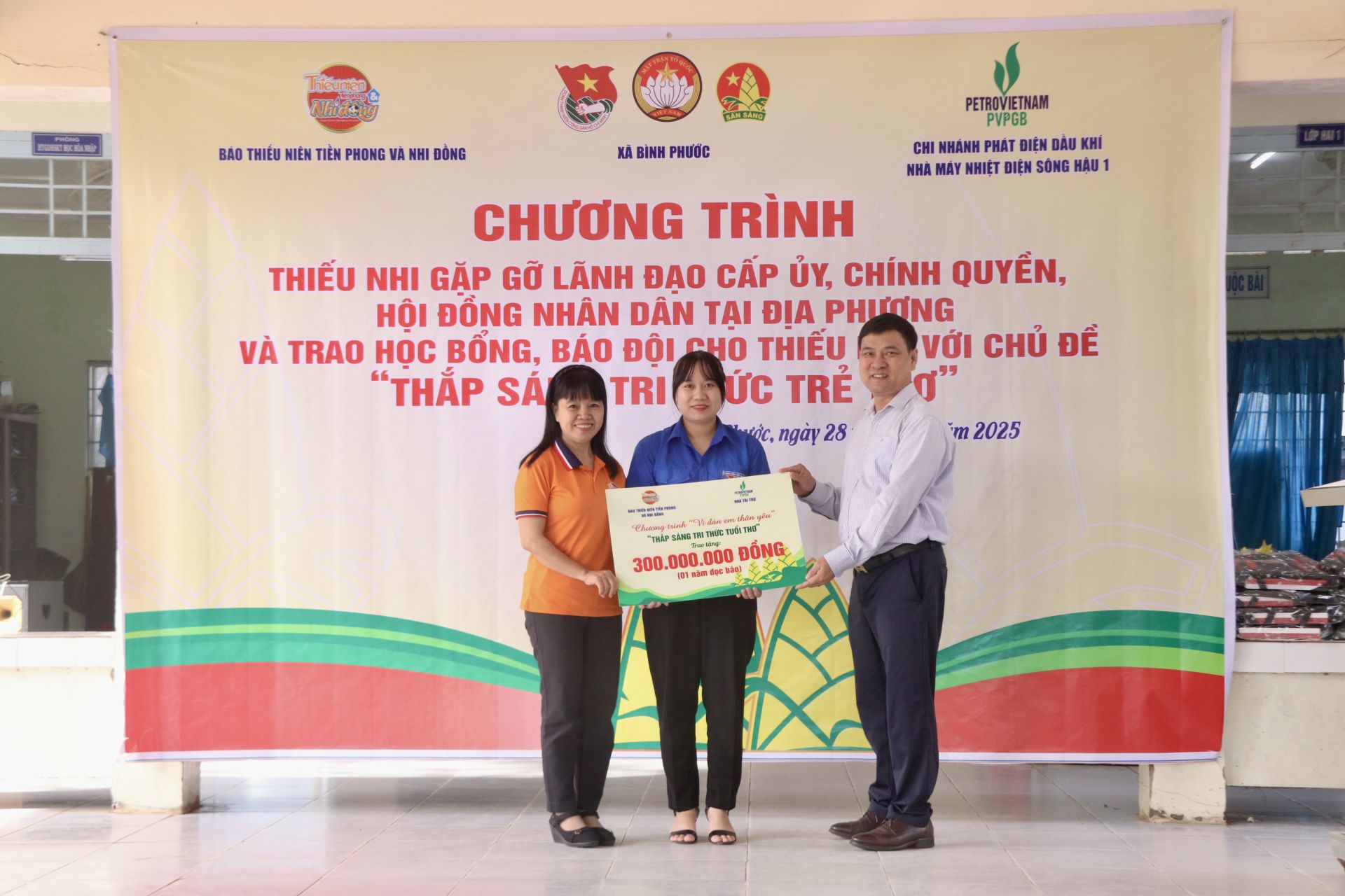 Nhà báo Ngô Hồng Phước – Trưởng Văn phòng đại diện Báo Thiếu niên Tiền phong & Nhi đồng  và ông Trần Hồng Hà – Phó Giám đốc Nhà máy Nhiệt điện Sông Hậu 1 trao bảng tượng trưng chương trình tặng Báo Đội trị giá 300 triệu đồng.