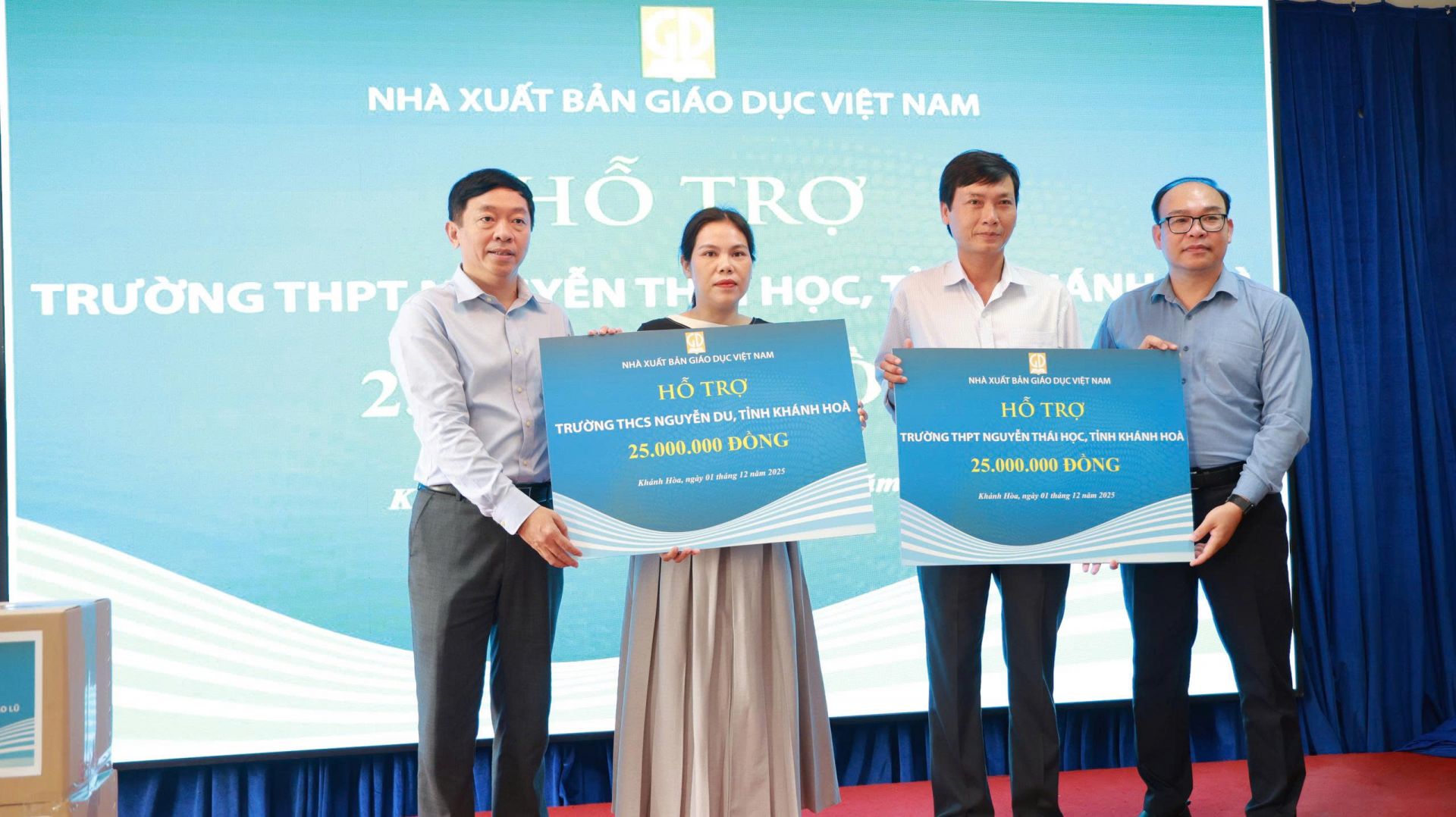 Bác Ông Thừa Phú (bìa trái) – Giám đốc NXBGDVN tại TP. Đà Nẵng và bác Đặng Thanh Hải Phó Tổng Giám đốc NXBGDVN  (bìa phải) trao biển tượng trưng số tiền hỗ trợ cho trường THPT Nguyễn Thái Học và trường THCS Nguyễn Du.