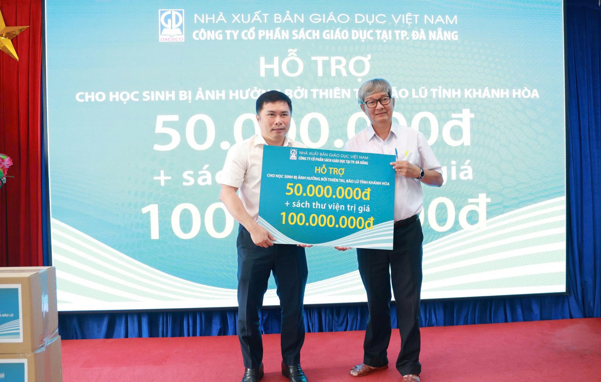 Bác  Lý Xuân Hoàn – Giám đốc Công ty CP Sách giáo dục tại TP. Đà Nẵng trao biển hỗ trợ tiền và sách tham khảo dùng cho thư viện trường học cho đại điện Sở GD- ĐT tỉnh Khánh Hòa.