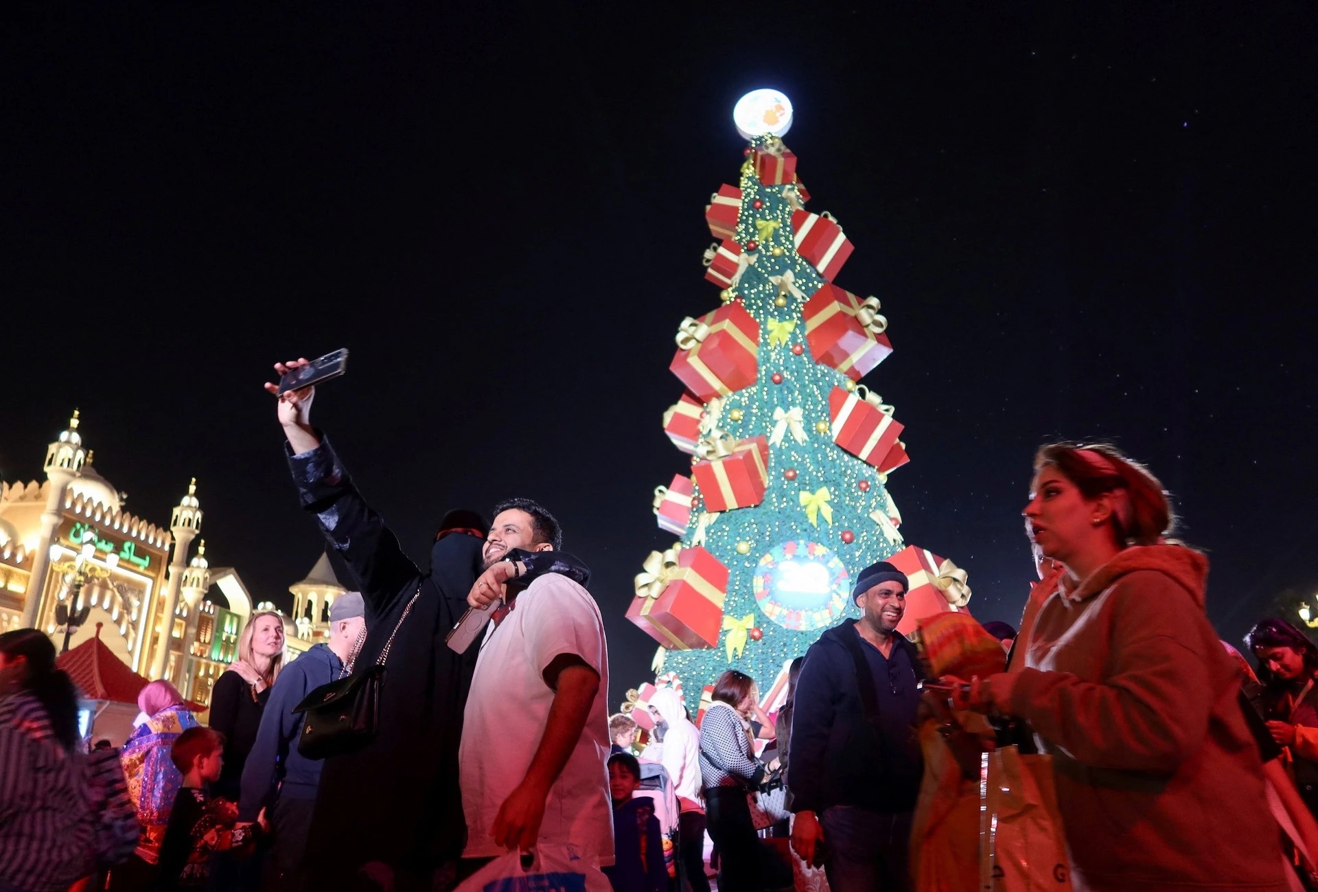 Người d&acirc;n chụp ảnh v&agrave; dạo bước trước c&acirc;y th&ocirc;ng Gi&aacute;ng sinh tại Dubai, C&aacute;c Tiểu vương quốc Arab Thống nhất, ng&agrave;y 20/12.