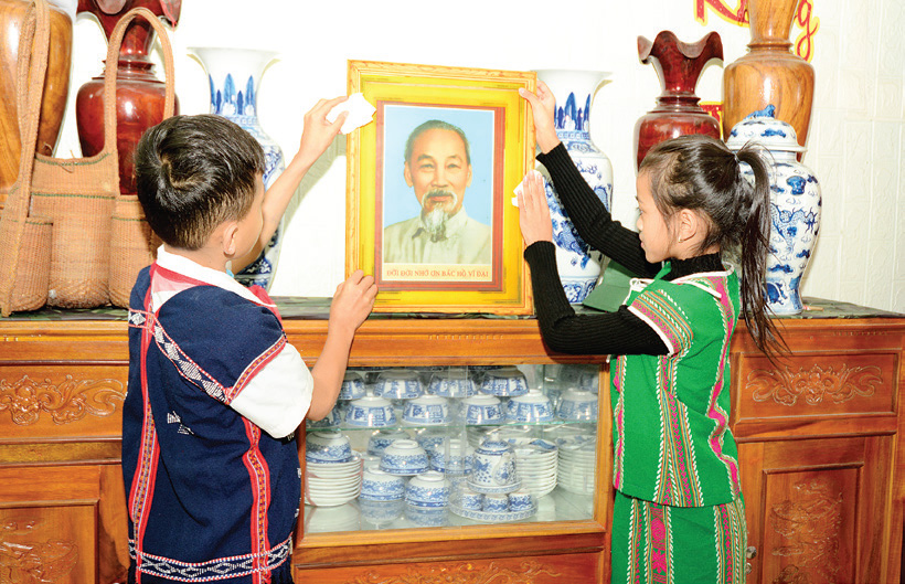 C&aacute;c bạn nhỏ
người Cơ Tu lau dọn
b&agrave;n thờ B&aacute;c Hồ để
chuẩn bị đ&oacute;n Tết
B&iacute;nh Ngọ.