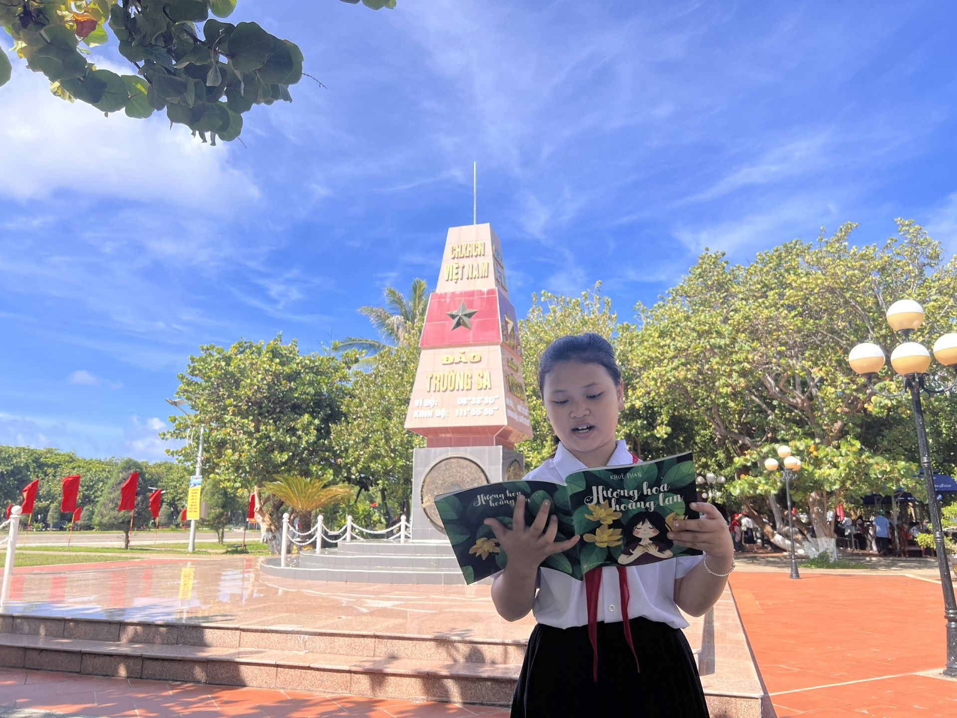 Em học sinh tr&ecirc;n đảo Trường Sa chăm ch&uacute; đọc s&aacute;ch b&ecirc;n cột mốc chủ quyền, h&igrave;nh ảnh b&igrave;nh dị nhưng gi&agrave;u &yacute; nghĩa về tinh thần học tập v&agrave; t&igrave;nh y&ecirc;u Tổ quốc nơi đầu s&oacute;ng ngọn gi&oacute;.