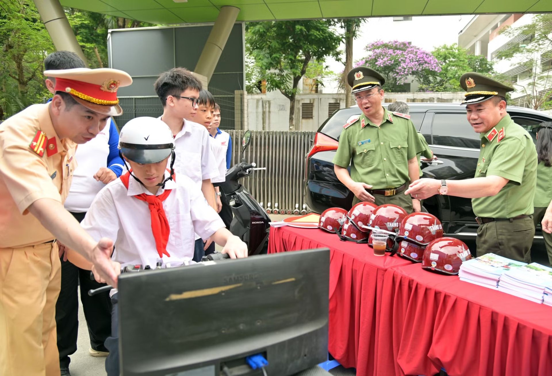 C&aacute;c đồng ch&iacute; l&atilde;nh đạo xem c&aacute;c em học sinh trải nghiệm kỹ năng l&aacute;i xe điện tr&ecirc;n m&ocirc; h&igrave;nh m&ocirc; phỏng.