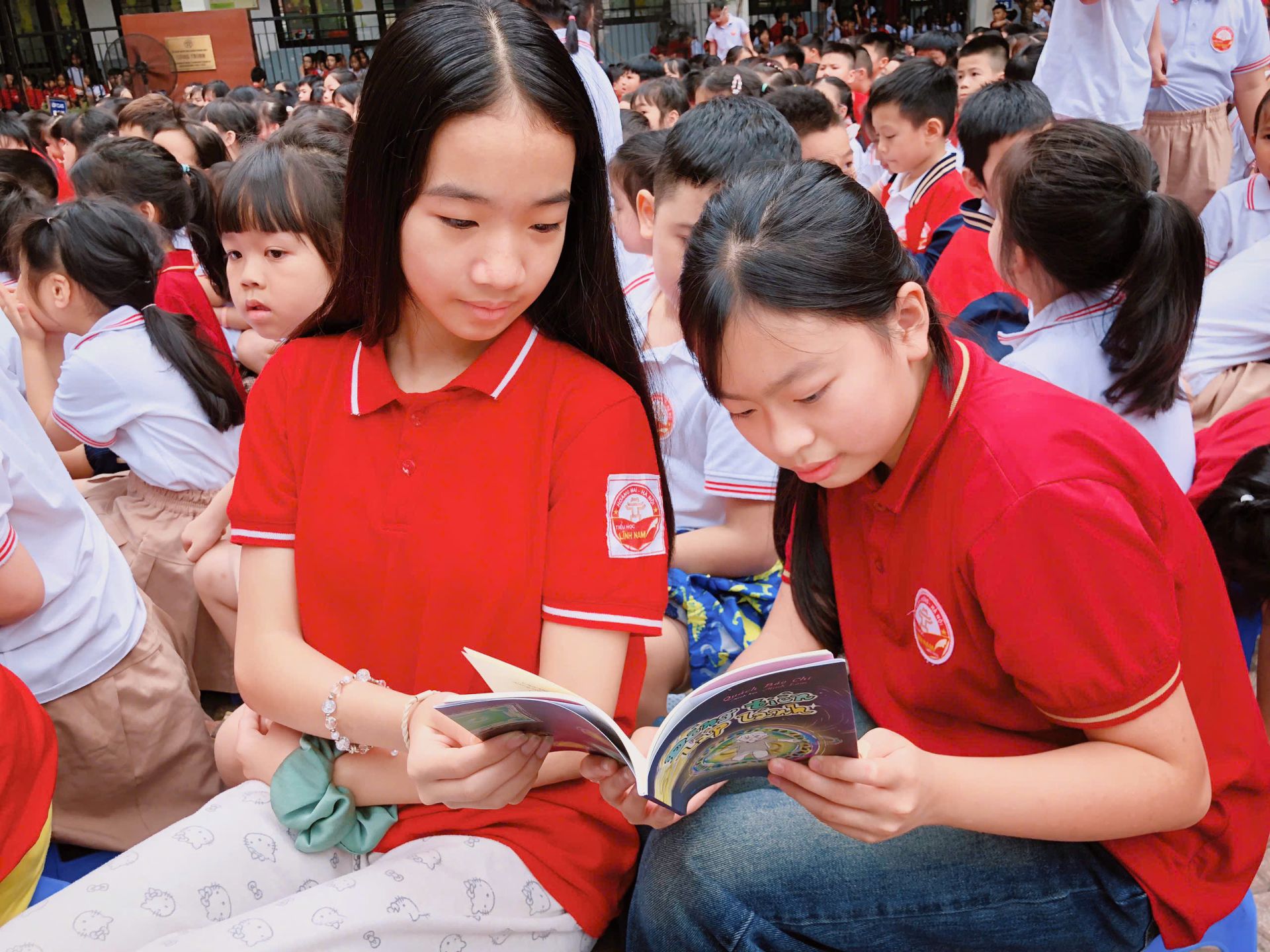 Hai bạn học sinh chăm ch&uacute; đọc cuốn s&aacute;ch &ldquo;Đồng tiền lấp l&aacute;nh&rdquo; của t&aacute;c giả trẻ Bảo Chi.