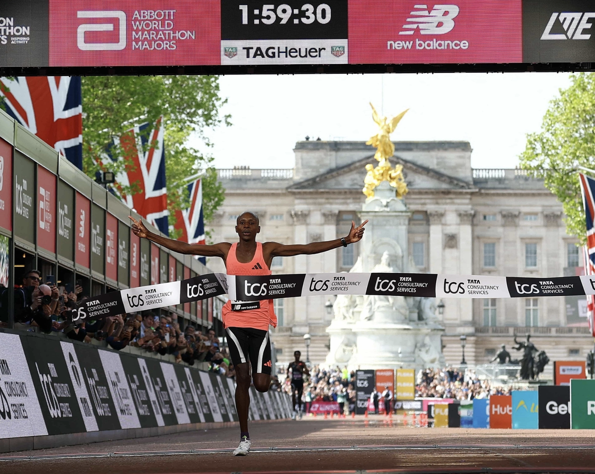 Sawe về nhất London Marathon 2026 trước cung điện Buckingham Palace khi đồng hồ điểm 1 giờ 59 ph&uacute;t 30 gi&acirc;y ng&agrave;y 26/4.