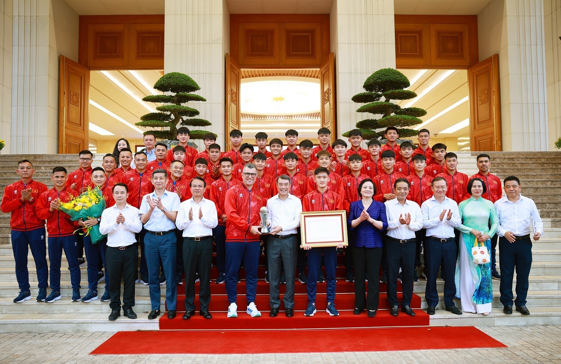 Thủ tướng L&ecirc; Minh Hưng với Ban huấn luyện v&agrave; c&aacute;c cầu thủ đội tuyển b&oacute;ng đ&aacute; nam U17 Quốc gia Việt Nam.