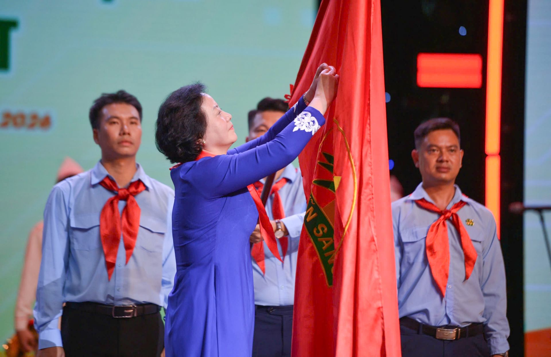 B&aacute;c Phạm Thị Thanh Tr&agrave; gắn Hu&acirc;n chương Lao động hạng Nhất l&ecirc;n l&agrave; cờ của Đội TNTP Hồ Ch&iacute; Minh.