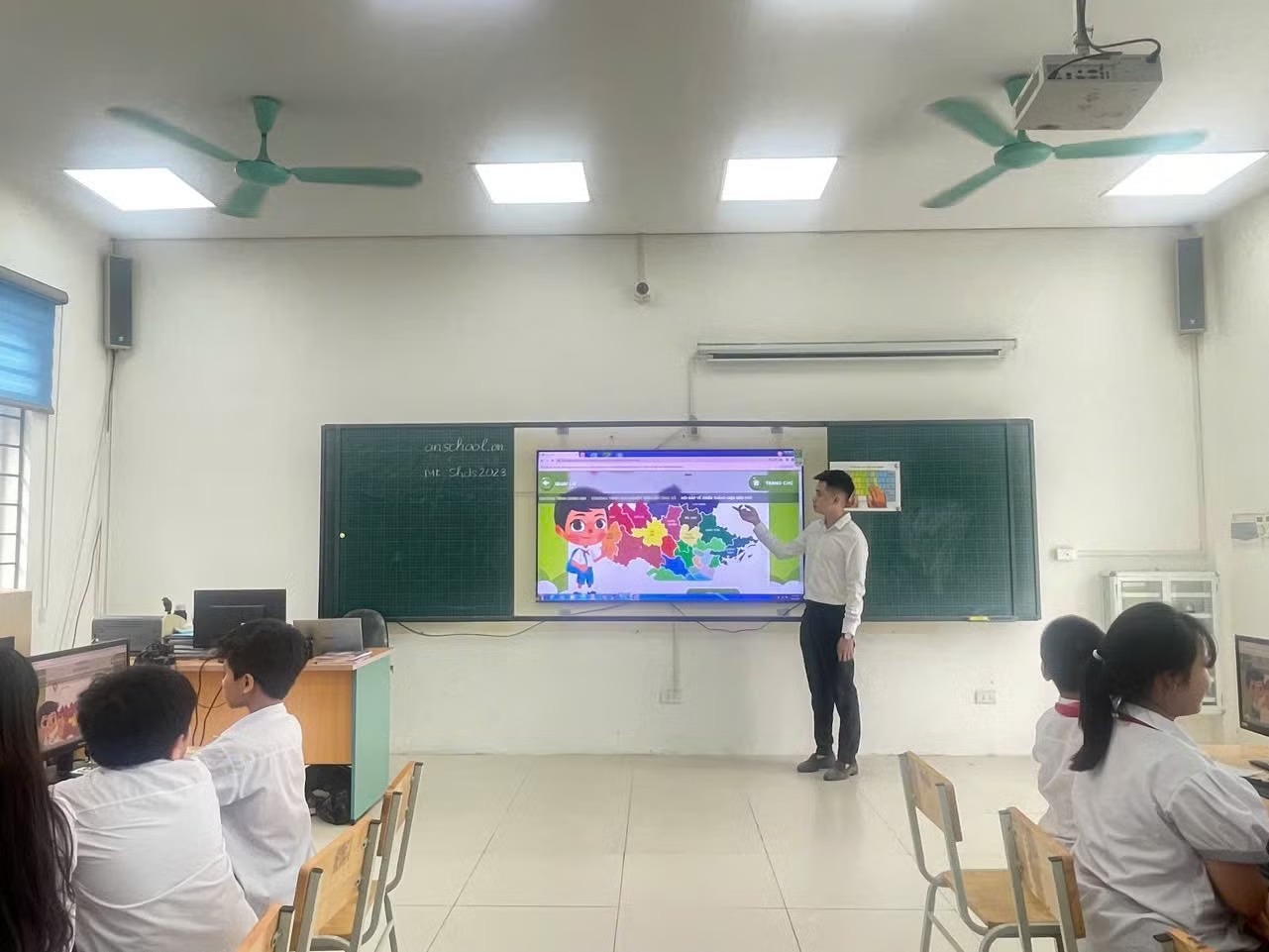 Th&acirc;̀y Nguy&ecirc;̃n Sỹ Qu&acirc;n cùng các học trò trong giờ học Lịch sử và Địa lý.