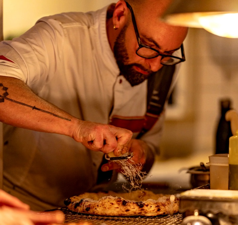 Một đầu bếp đang l&agrave;m m&oacute;n pizza tại nNea (Amsterdam, H&agrave; Lan).