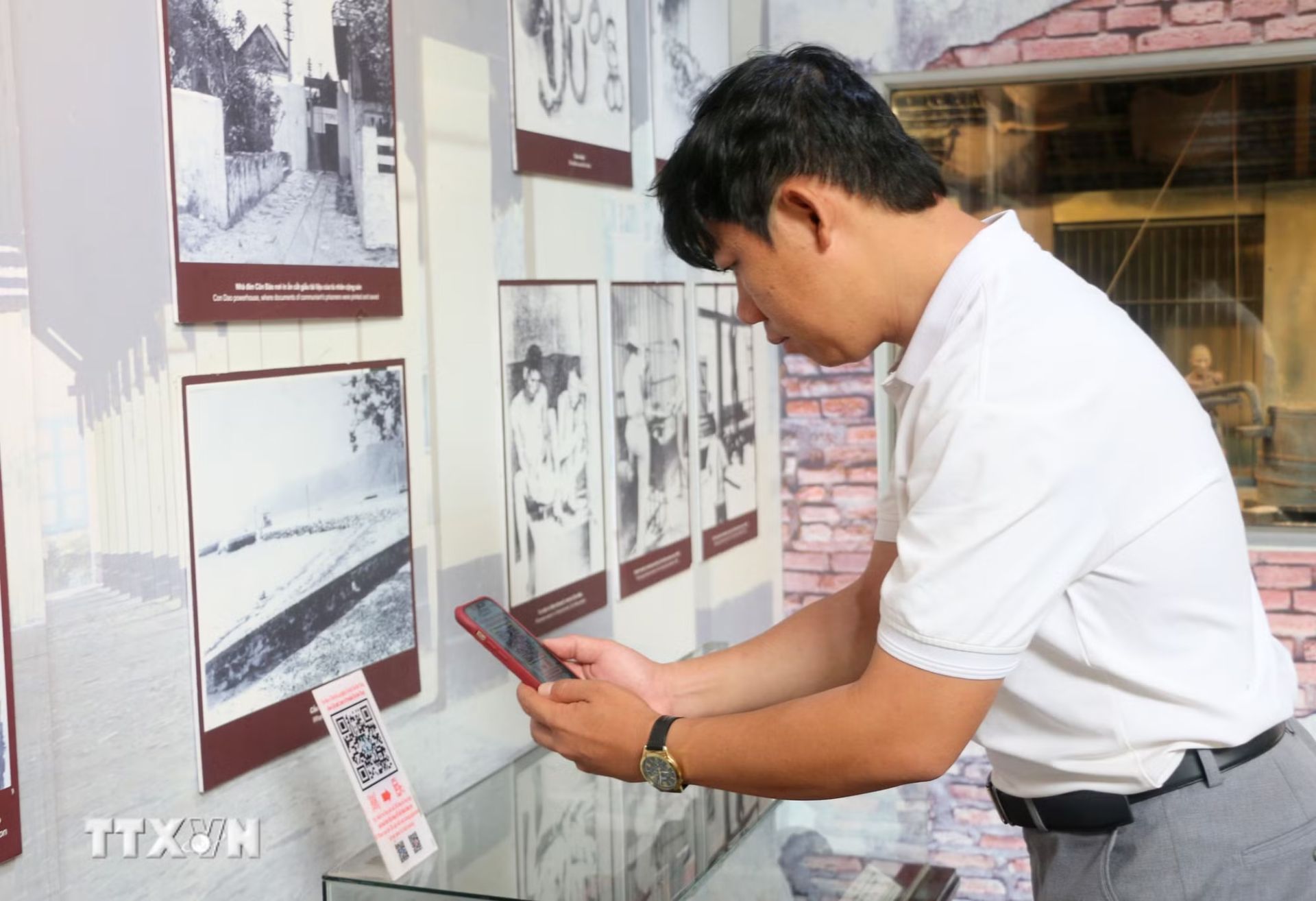 Du kh&aacute;ch qu&eacute;t QR để t&igrave;m hiểu th&ocirc;ng tin tại Nh&agrave; trưng b&agrave;y th&acirc;n thế, sự nghiệp Chủ tịch T&ocirc;n Đức Thắng, nằm trong Khu lưu niệm Chủ tịch T&ocirc;n Đức Thắng, thuộc x&atilde; Mỹ H&ograve;a Hưng, tỉnh An Giang (Ảnh: C&ocirc;ng Mạo/TTXVN).