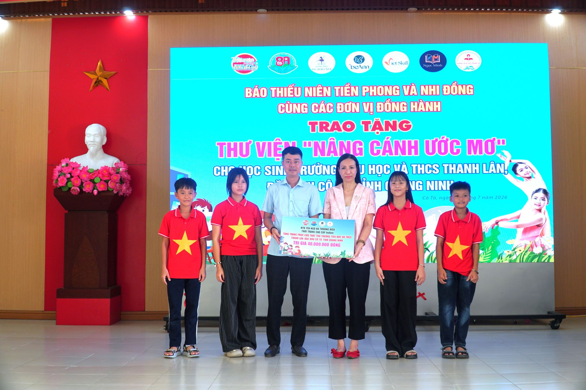 NTK Yến Ng&ocirc; - CEO thương hiệu thời trang cao cấp BeAnn (&aacute;o hồng) trao m&oacute;n qu&agrave; trị gi&aacute; 40 triệu đồng gồm &aacute;o cờ đỏ sao v&agrave;ng, &aacute;o đồng phục v&agrave; khăn cho trường TH v&agrave; THCS Thanh L&acirc;n.