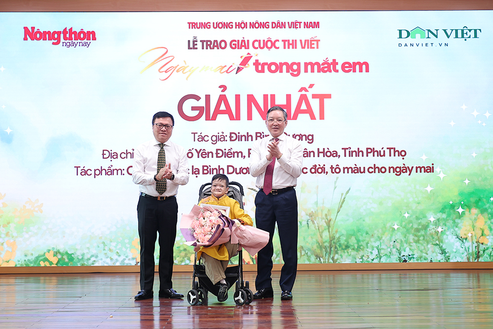 Nh&agrave; b&aacute;o L&ecirc; Quốc Minh (b&ecirc;n tr&aacute;i) v&agrave; b&aacute;c Lương Quốc Đo&agrave;n trao giải Nhất Cuộc thi viết &ldquo;Ng&agrave;y mai trong mắt em&rdquo; cho t&aacute;c giả Đinh B&igrave;nh Dương.