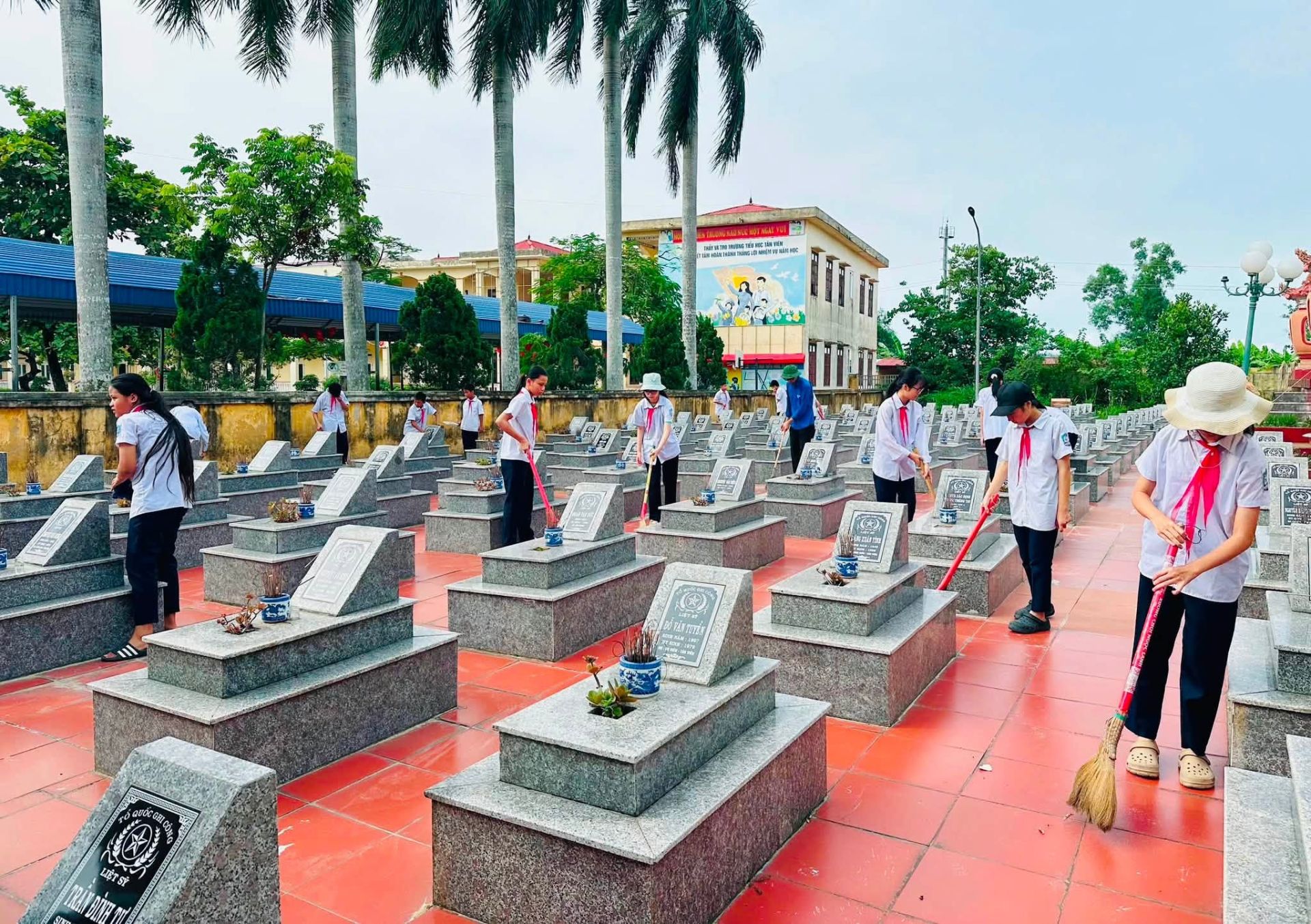 Học sinh trường Ti&ecirc;̉u học T&acirc;n Vi&ecirc;n (xã An Khánh, TP. Hải Phòng) quét dọn nghĩa trang li&ecirc;̣t sĩ tại địa phương.